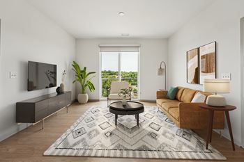 A living room with a brown couch, a black coffee table, and a large window